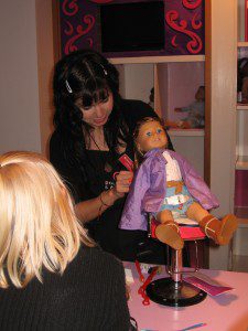 an-american-girl-doll-getting-her-hair-done-at-the-hair-salon-while-her-owner-looks-on
