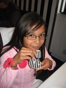 gabriella-sipping-milk-from-her-tiny-cup-and-saucer-at-the-american-girl-cafe