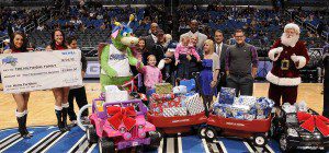 Orlando Magic CEO Alex Martins, Ellyn Stern-Rivkees from Chase and Jennifer Rhodes from Operation Homefront honored Army Sergeant First Class Paul Hiltibidal, his wife Lindsey and children Jilyanne (age 8), Lexi (age 3), Gabe (age 2) and Illyana (6 months) during the Magic’s “Big Give” at halftime of the Magic vs. Jazz contest on December 23. (Photo: Gary Bassing/Orlando Magic)