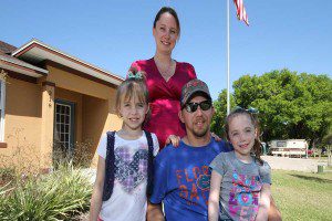 U.S. Army staff Sergeant Jeffery Kelly (retired) with wife Michelle and two daughters, Jade and Lindsey, outside their new home, 218 West Oakland Avenue, Oakland, FL. (Photo credit: Home At Last)