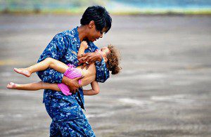 REASSURING RESCUE - Navy Lt. Lori Campbell carries a young girl to safety on Naval Air Station Joint Reserve Base New Orleans, La., Sept. 1, 2012, following Hurricane Isaac, which struck the area Aug. 28. Members of Louisiana Army National Guard units evacuated the girl from Port Sulphur, La. U.S. Air Force photo by Master Sgt. Dan Farrell