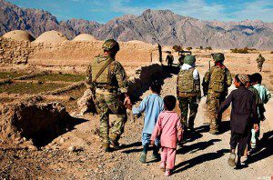 PATROL BUDDIES - Afghan children walk alongside a coalition force member during a presence patrol in Farah province, Afghanistan, Dec. 9, 2012. U.S. Marine Corps photo by Sgt. Pete Thibodeau 