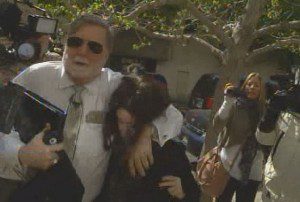 Casey Anthony holds down her head as she is held closely by attorney Cheney Mason, as they run the gauntlet of photographers, into the Federal Courthouse in Tampa, Monday, March 4, 2013 (Video still- cfnews13.com)