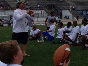 DP Coach teaches kids how to pass and punt at Youth Football Combine, Bill Spoone Stadium, June 1, 2013 (Photo: WONO)