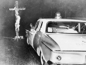 Chicago police move in to knock down a burning cross in front of a home, after an African-American family moved into a previously all white neighborhood, on the 6th consecutive night of disturbances, on August 3, 1963. (Library of Congress)