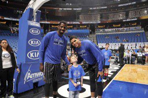 Magic players Andrew Nicholson (left) and Tobias Harris (right) visit with six-year-old Trevor Scheerer before the Magic game on Nov. 8.  Scheerer was diagnosed with rhabdomyosarcoma, a form of cancer most common in children, and through the Kasie Helpz Kidz organization was invited to come to a game and meet the players. (Photo credit: Gary Bassing).