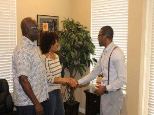 Personal touch.  Focus 9 Enterprises C.E.O. Akil Yisrael greets two of his clients in Deltona recently.  (Karsceal Turner-WONO).