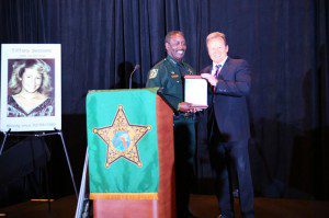 Orange County Sheriff Jerry Demings (l) presents Attorney Dan Newlin (r) with a plaque in recognition of his continuous support of the annual Sheriff's Office Community Crime Summit.  A poster of 20-year-old Tiffany Sessions of Gainesville, FL, missing since February 1989 is displayed. Missing and exploited children was one of the topics discussed at the '2014 Sheriff's Office Community Crime Summit, on September 29, 2014. in Orlando.  
