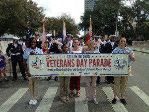 OSS 12th grade students holding Veterans Day Parade banner. From left to right, Chimisha Chery of Orlando; Brittany Grandison of Ocoee; Ashley Gunter of Altamonte Springs; Brittany Oakes 12th of Ocoee and OSS Administrative Assistant Ms. Becc-Sanford (Photo courtesy: OSS)