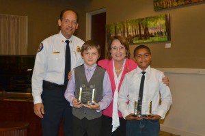 Orange County Mayor Teresa Jacobs and Orange County Fire Chief Otto Drozd honor Isiah Francis and Jeremiah Grimes with the Mayor's Hero Award and an Honorary Firefighter plaque at a recent Board of County Commissioners meeting.